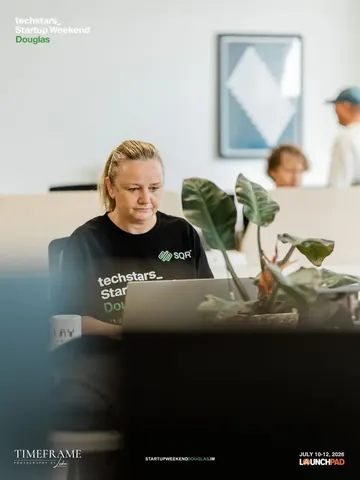 Emma Kneale working on ProfitM8 at a laptop during Techstars Startup Weekend Douglas